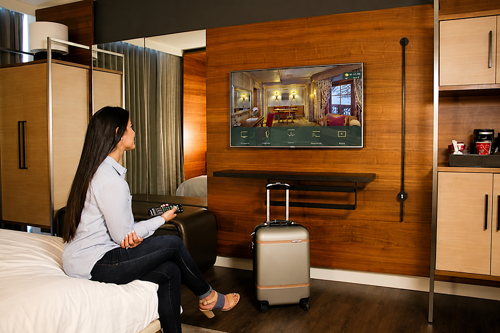 woman in front of smart tv in hotel room
